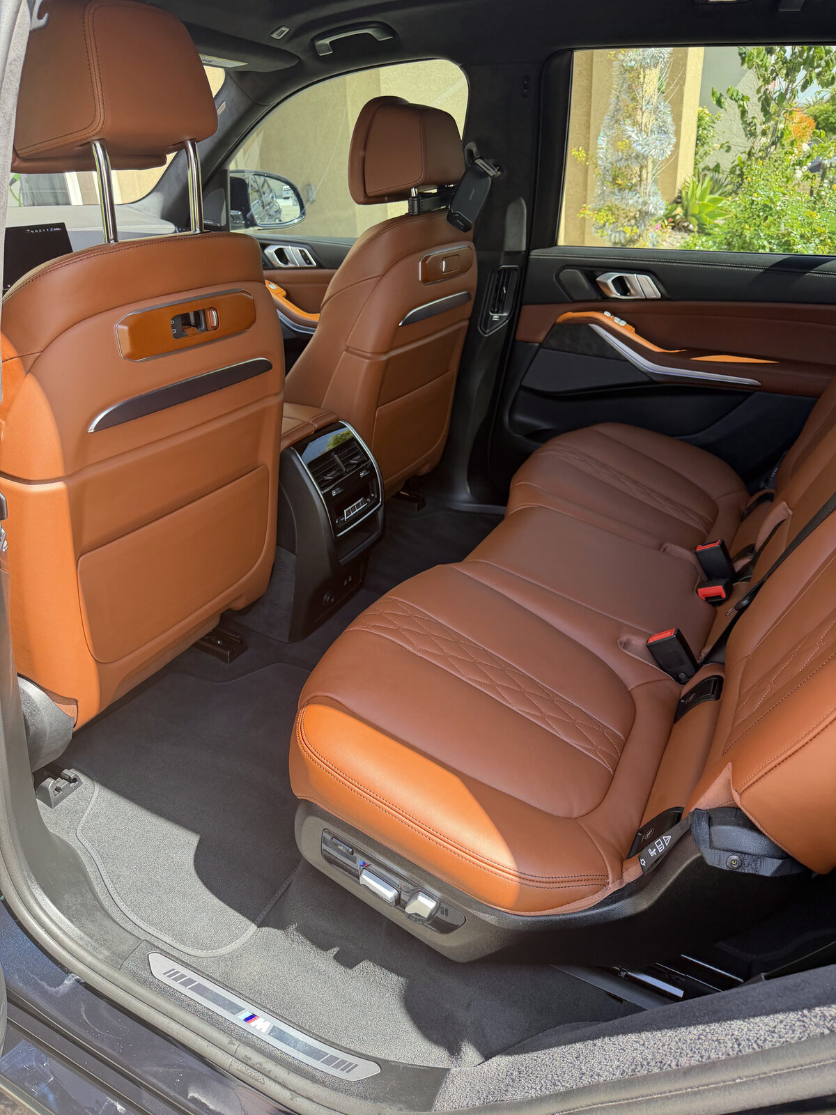 Conditioned cognac leather rear seats in a detailed BMW SUV